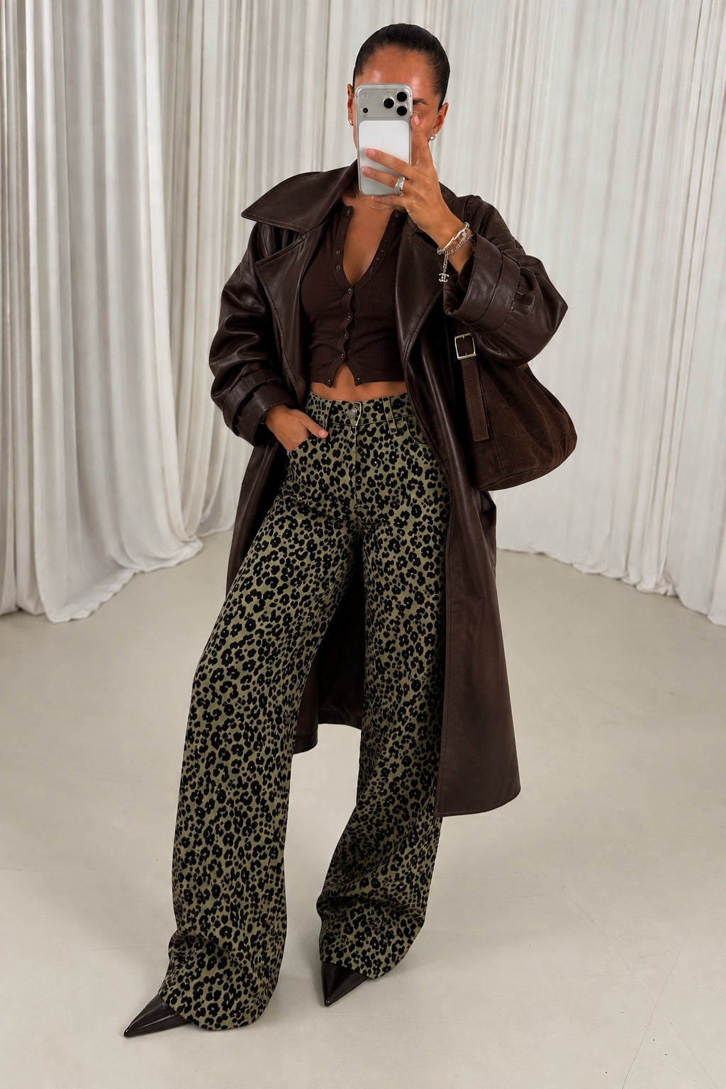 Green leopard print wide leg jeans styled with brown leather coat