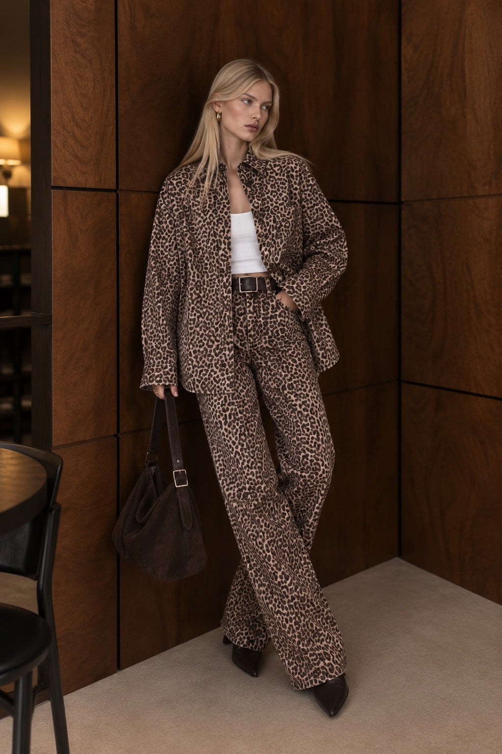 Leopard print wide-leg jeans styled with matching leopard shirt and brown bag